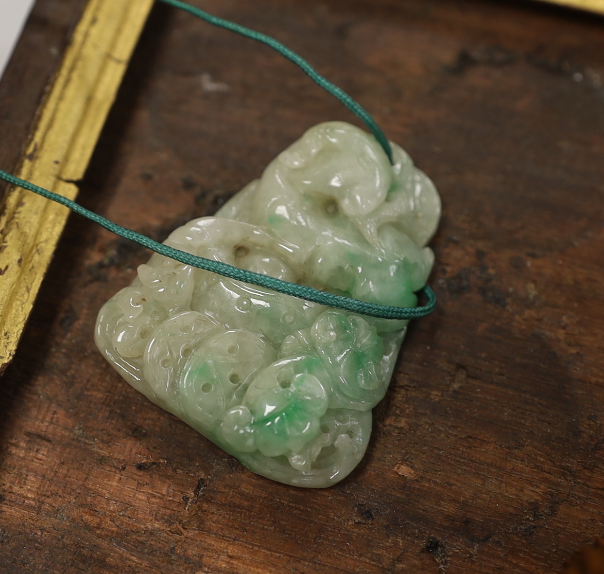 Five Chinese jadeite pendants and two wood lion-dog netsuke, netsuke 3.5 high